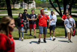 Students attend a campus tour and the tour leader points toward the camera