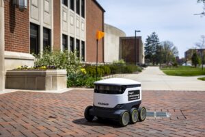 A food delivery bot drives through campus.