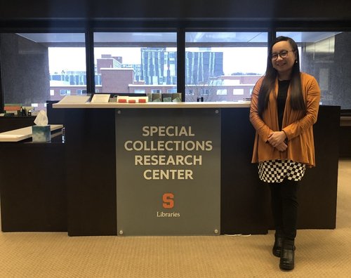 an asian woman is standing in front of a research presentation