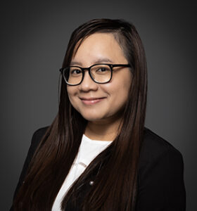 headshot of an asian woman with glasses smiling