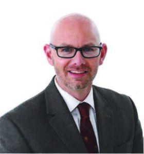 headshot of a man with glasses
