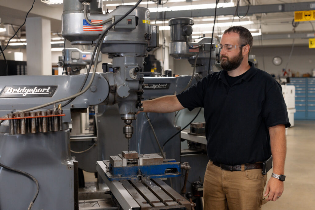 Man standing next to precision machinery.