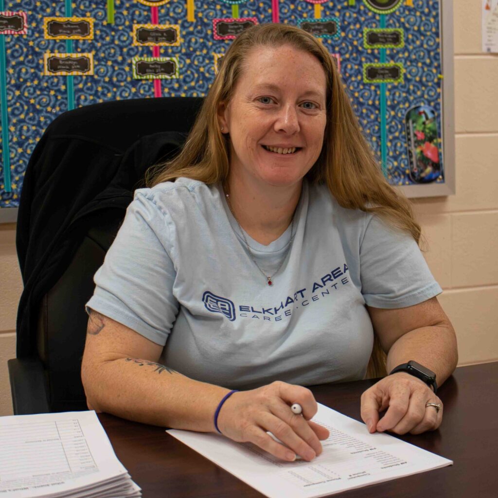 Woman sitting at a desk grading papers.