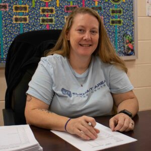 Woman sitting at a desk grading papers.