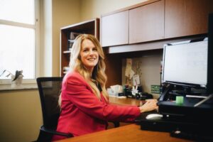 Ball State University alumna and Superintendent for Whitko Community School Corporation, Amy Korus, sits at her desk working on her computer. Amy has her EdD in Educational Administration from Ball State.