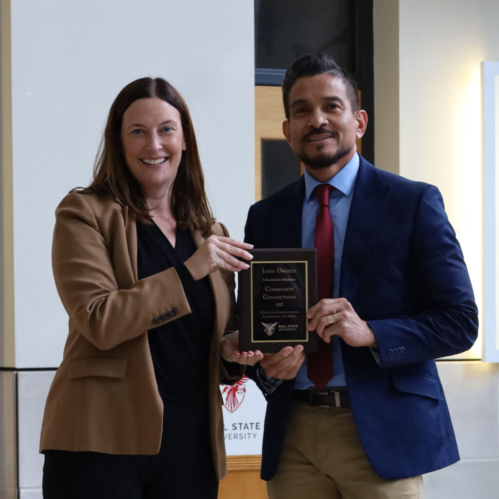 CCIM Dean Kristen McCauliff awards Luis Orozco with the Community Connections Award.