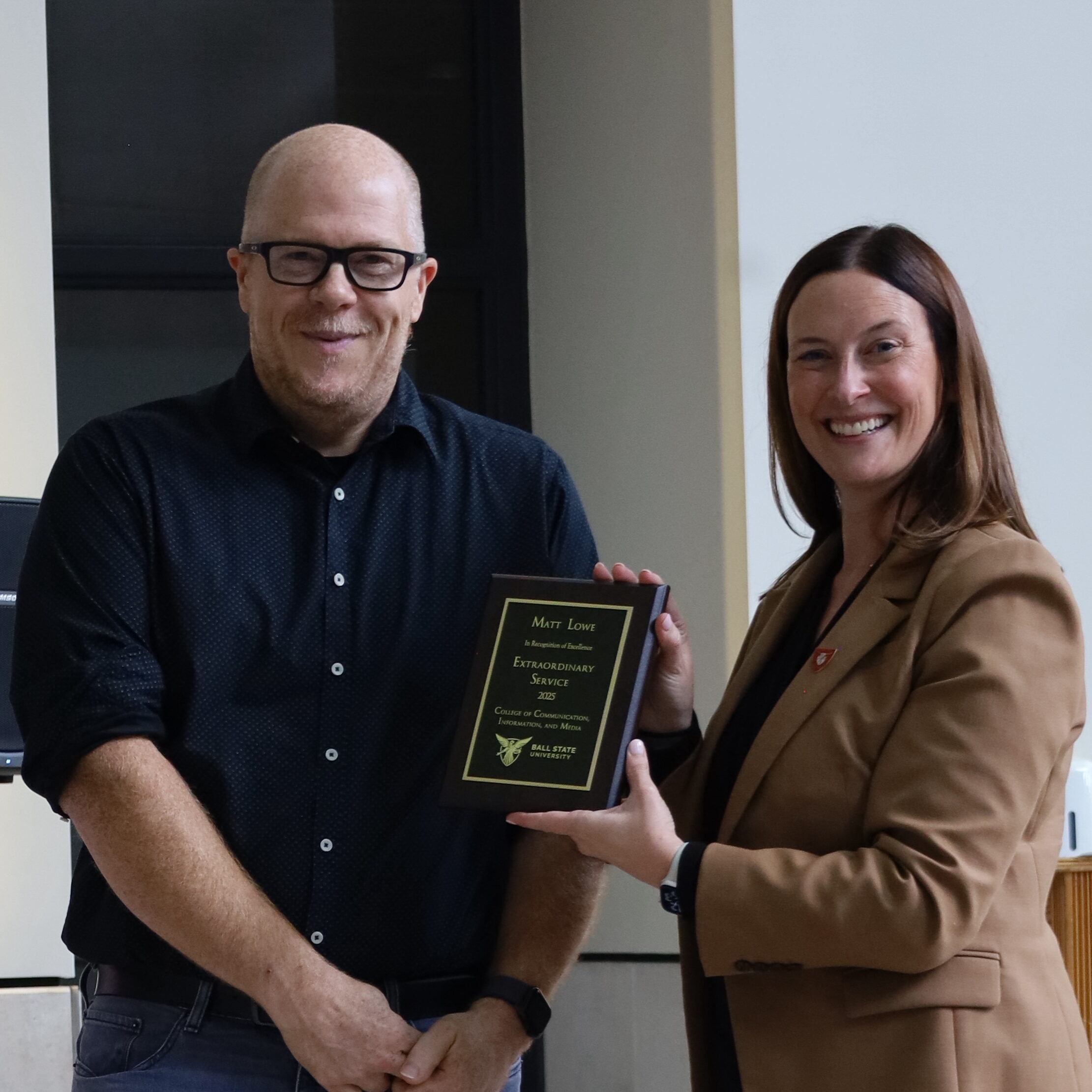 CCIM Dean Kristen McCauliff awards Matte Lowe with the Extraordinary Service Award.