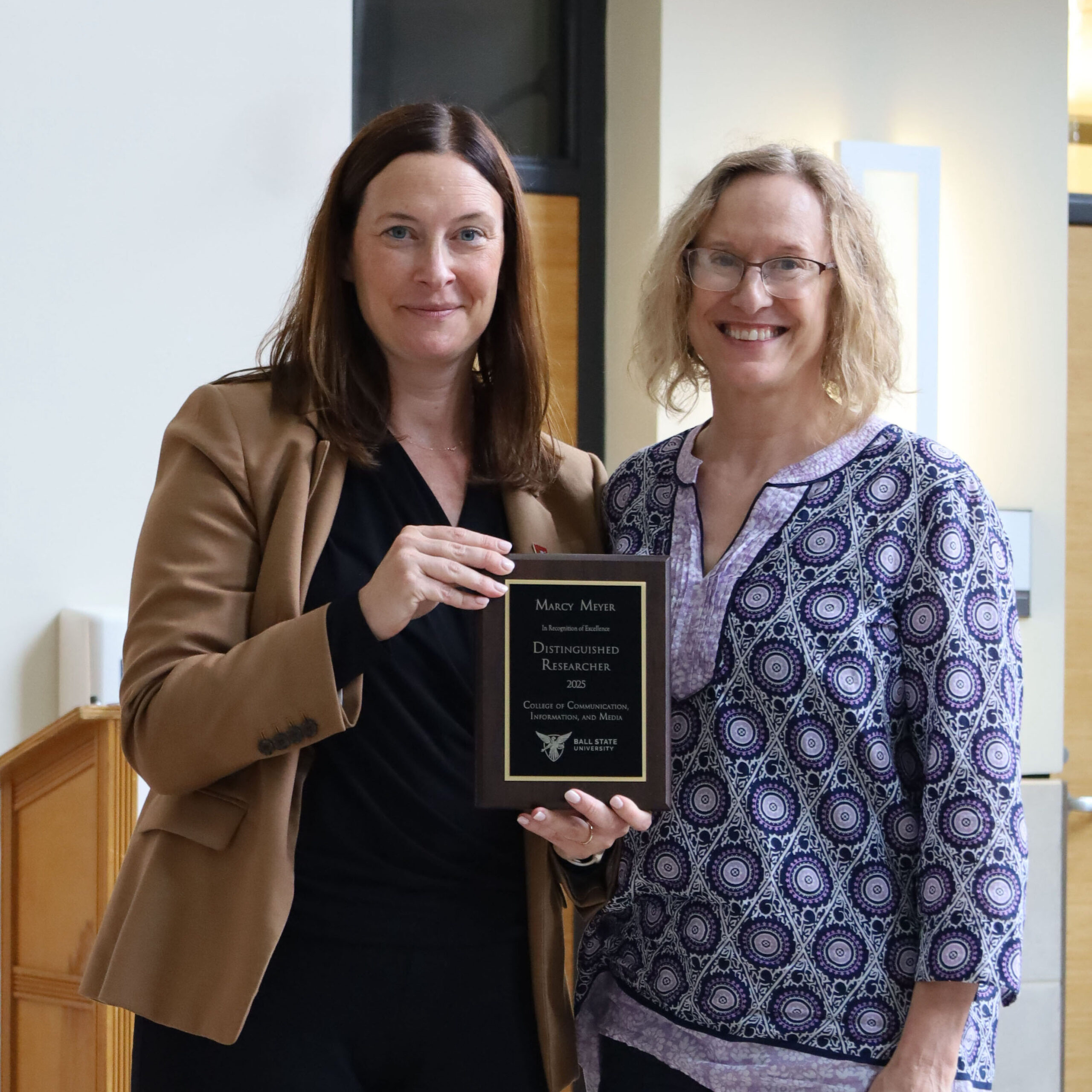 CCIM Dean Kristen McCauliff awards Marcy Meyer with the Distinguished Researcher Award.