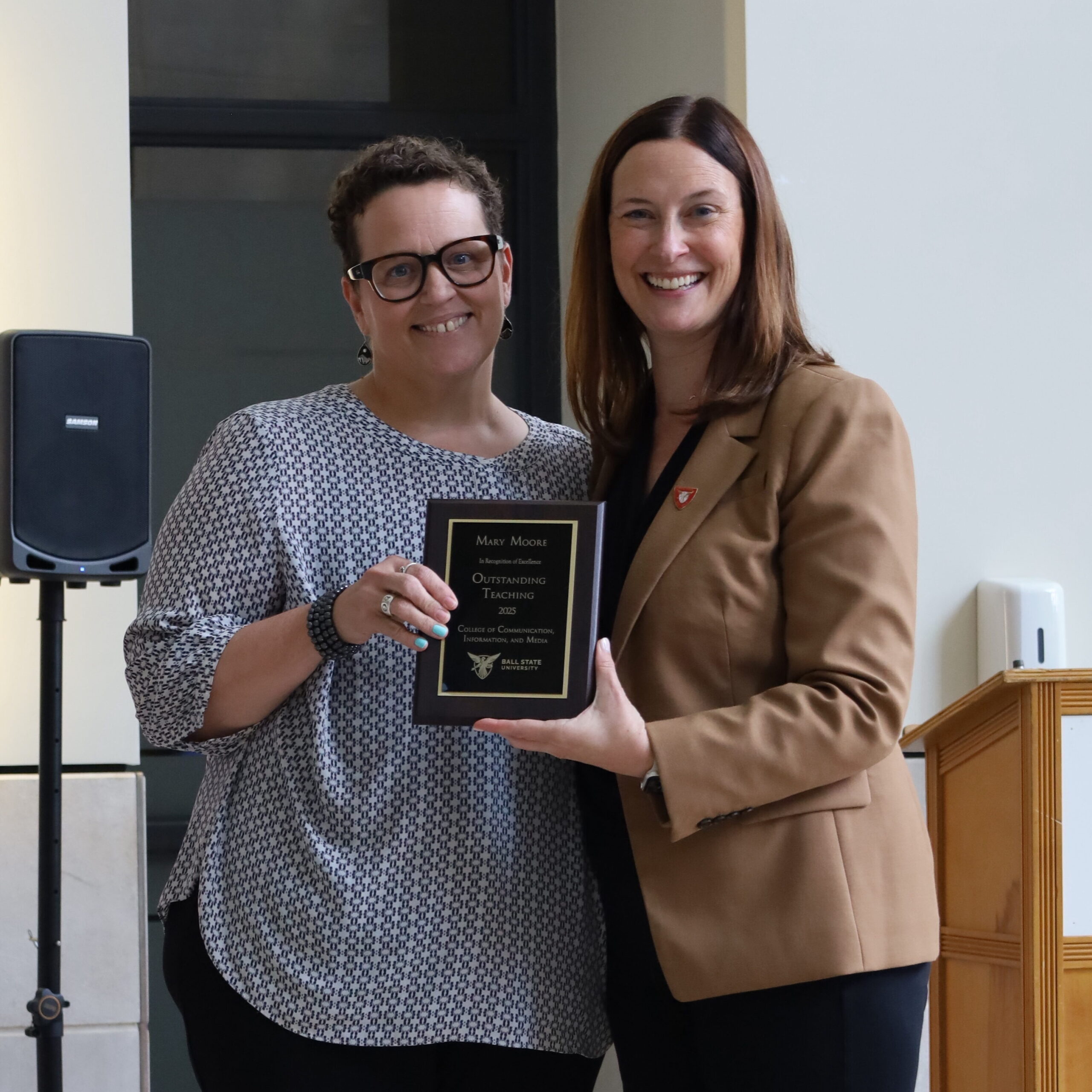 CCIM Dean Kristen McCauliff awards Mary Moore with the Outstanding Teacher Award.