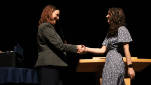 Horizontal Photo of CCIM Dean Kristen McCauliff shaking the hand of student Amelia Harker at the Dean's List 2025.