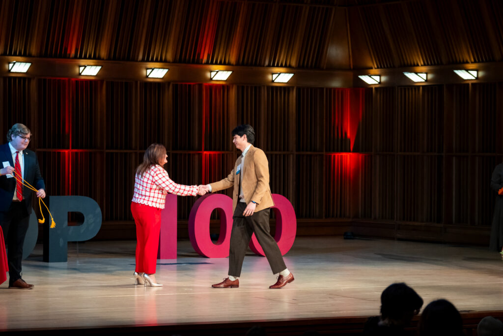 two people shaking hands on a stage