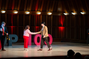 two people shaking hands on a stage