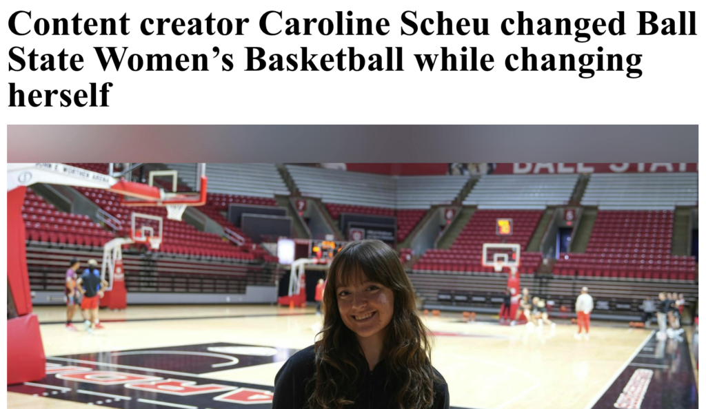Caroline Scheu smiles while standing on the Ball State Women's Basketball court inside Worthen Arena, with players warming up and the red Cardinal logo visible on the hardwood behind her. The photo accompanies a sports feature about her work as a content creator for the program.