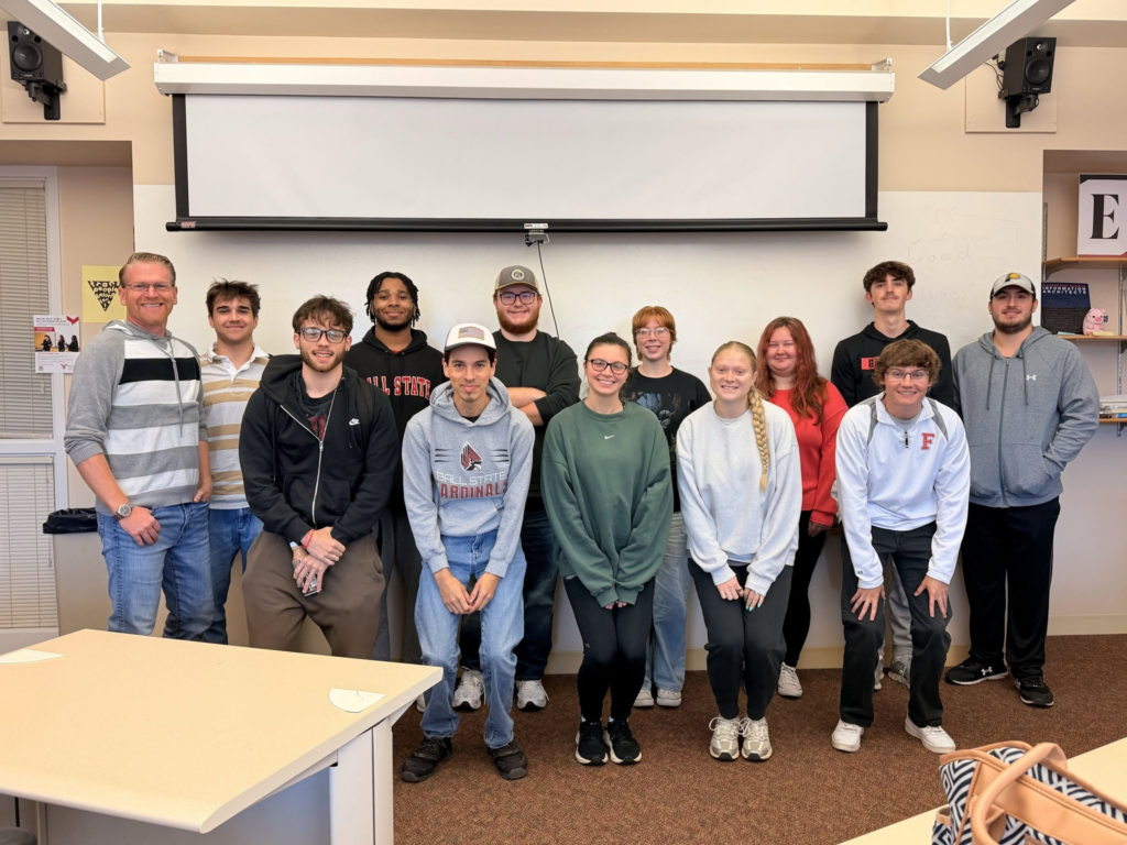 Dr. Adam Kuban and his Journalism 322 class pose for a photo in their classroom. 