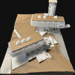 The top view of the physical model put together by Aiden. The model of the building is created with tag board, corrugated board, 3D printed pieces for the building showing the elevations of the land it would be built on.