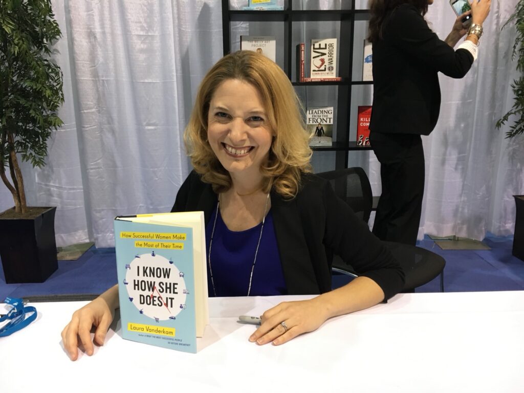 Laura Vanderkam posing with her book, "I Know How She Does It."