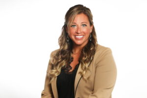 Head shot of Carrie Lively in a brown jacket.