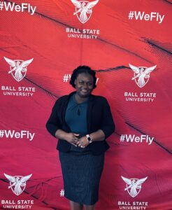 woman posing for picture in front of red backdrop