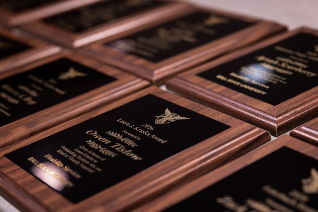Several award plaques sit on a table ready to be given as awards to our student winners