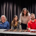 Tiffany Peters (AVP for Student Affairs), Ethan Hines and Mac Cook (Assistant Directors of Disability Services), and Sharon Harper (Administrative Coordinator) share a photo together in front of the Disability Services award plaques they are preparing to award.