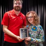 Student Ayvah Scarberry and Ethan Hines (AD Disability Services) pose for a photo with the Gilbert Award plaque
