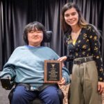 Student Zach Deardorff and Mac Cook (AD Disability Services) pose for a photo with the Fehribach Award plaque