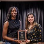 Student Kelsey Sykes and Mac Cook (AD Disability Services) pose for a photo with the Fehribach Award plaque
