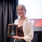 Student Emilee Allen poses for a photo with the Gilmer-Adamson Award plaque
