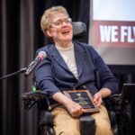 Alum Mary Jo Day speaks while holding her award plaque after receiving her Outstanding Alumnus Award