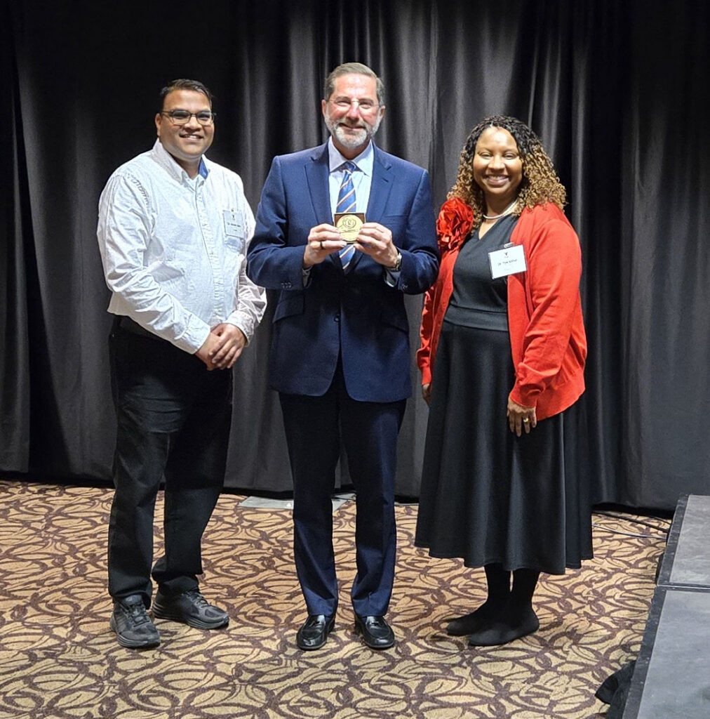 Dr. Nimish Valvi, Alex M. Azar II, and Dr. Tya Arthur pose after Dr. Azar was presented with the 2026 McGovern Award. 