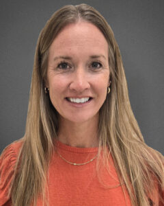 Headshot of Rebekah Ferrell. She is Caucasian and wearing an orange shirt, and has long straight honey blonde hair. She is smiling. 