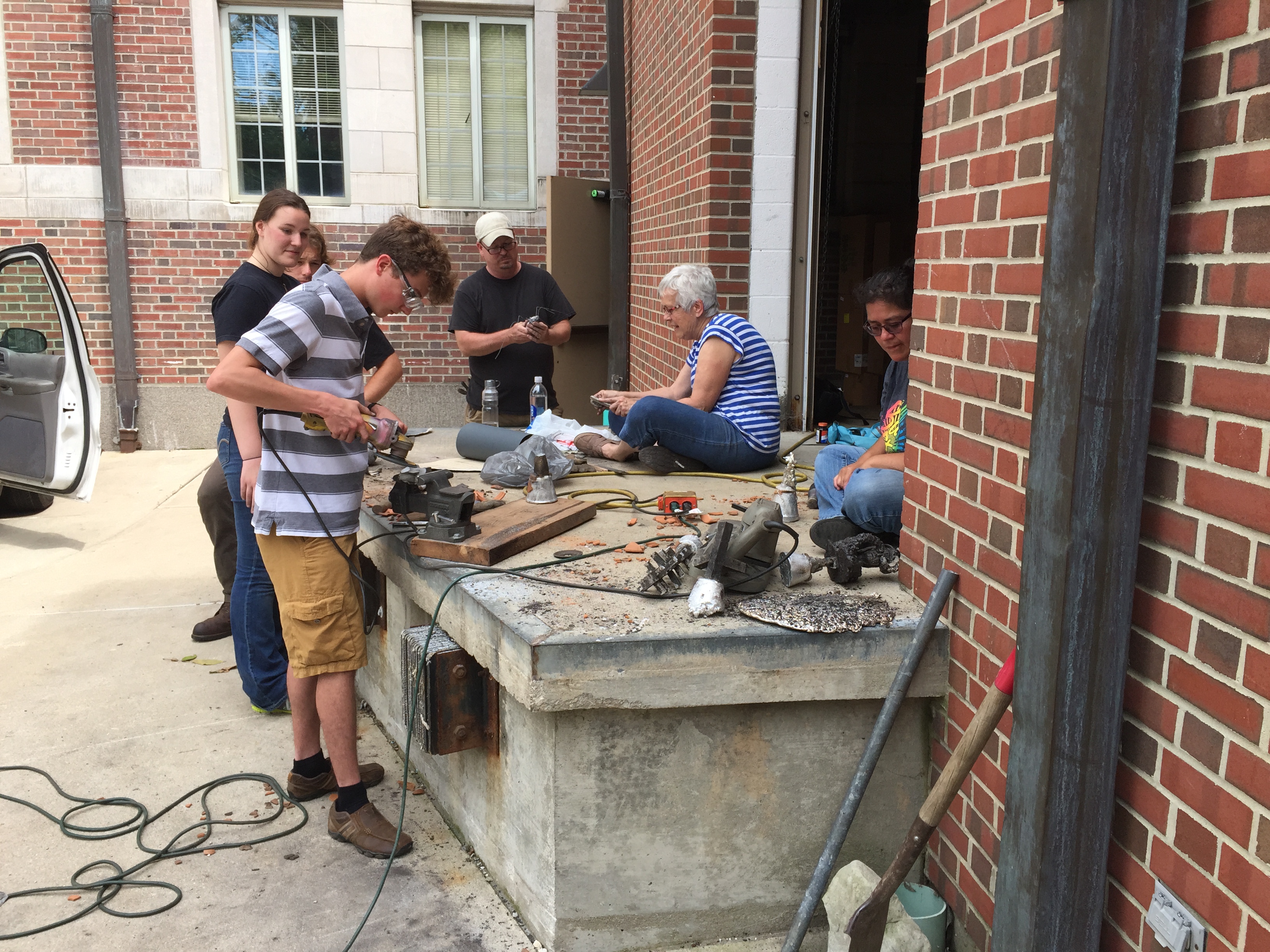 The students pouring aluminum into their molds