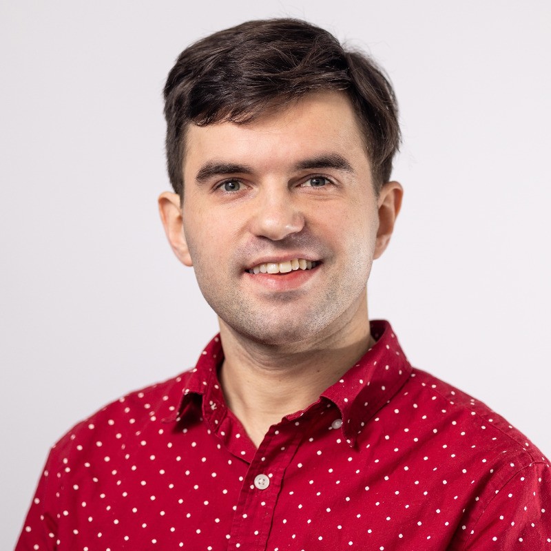 A man with dark hair in a red shirt