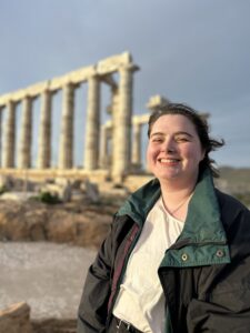 young woman with brown hair in front of columns