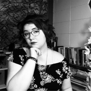 black and white photo of young woman with dark hair and glasses